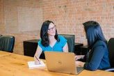 Positive Candidate Experience gestalten 2 Frauen sprechen vor einem Laptop zueinander